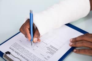 Maryland Workers Compensation Lawyers - Injured Man Filling Insurance Claim Form