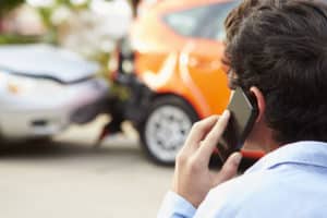 fairfax car accident lawyer-man makes phone call while looking at rear ending car accident