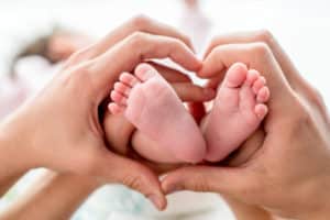 Maryland birth injury lawyer-baby's feet framed by mother's hands.